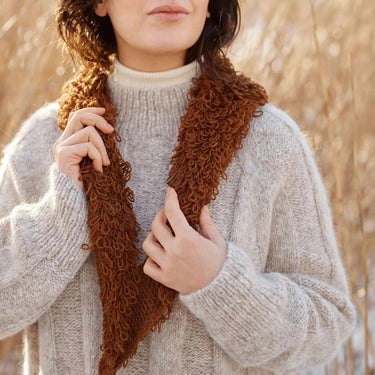 Winter knitwear featured in Laine Magazine Issue 27 with cozy cable knit sweater and textured scarf, showcasing winter knitting designs.