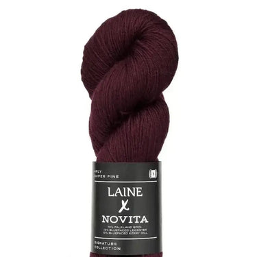 Burgundy skein of yarn with Laine Novita label on a white background