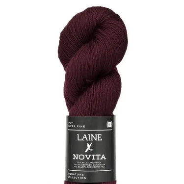 Burgundy skein of yarn with Laine Novita label on a white background