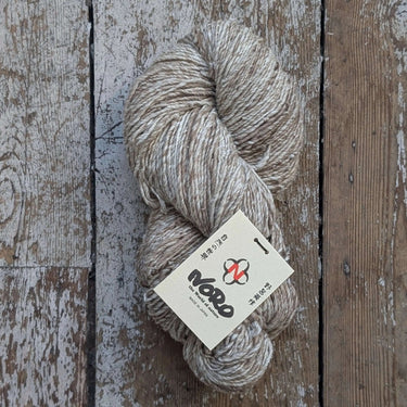 Skein of Noro Haunui Silk yarn in natural color on rustic wooden surface