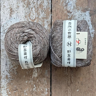 Noro Haunui natural merino wool yarn from Taranui farm, New Zealand, displayed in 200g skeins on rustic wooden background.