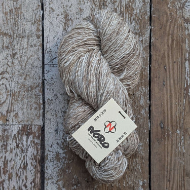 Skein of Noro Haunui Silk yarn in natural color on rustic wooden surface