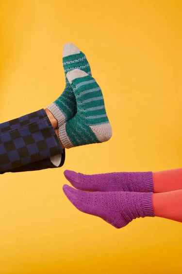 Colorful socks illustrated in the Knitting Book "Ready Steady Sock" against a vibrant yellow background.