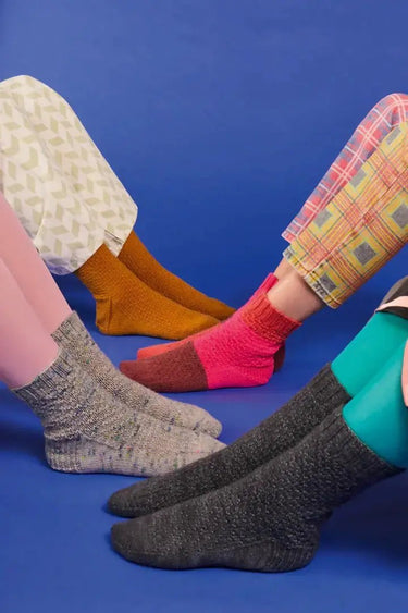 Colorful sock designs featured in Knitting Book by Pom Pom, showcasing creativity and diversity in sock patterns.