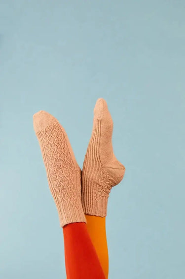 Colorful knitted socks from Knitting Book by Rachel Cooper, showcasing intricate designs against a blue background.