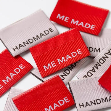 Red and gray labels with 'ME MADE' and 'HANDMADE' text on a white background