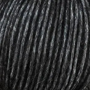 Snefnug yarn close-up showcasing black and white fibers, made from baby alpaca, merino wool, and organic cotton.