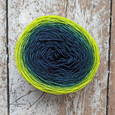 Snek yarn by Bilum in gradient merino wool with sport and fingering weight on rustic wooden background.