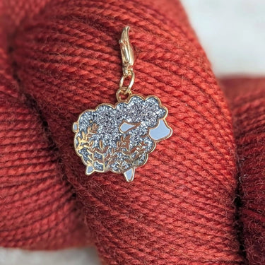 Twill + Print Progress Keepers with silver sheep charm on red yarn for knitting and crochet projects.