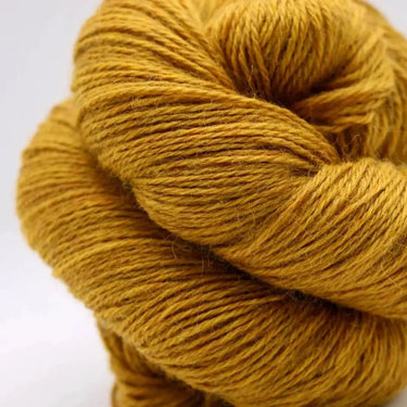 Mustard yellow skein of yarn on a white background
