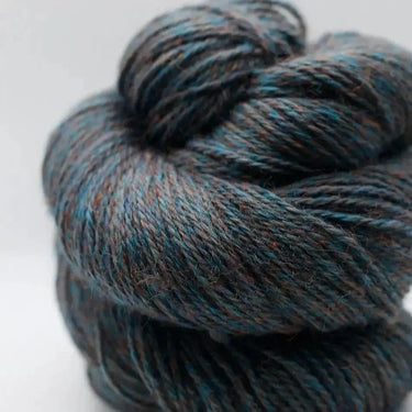 Close-up of Yarnadelic Sport yarn, rustic blend of Falklands Corriedale fibers, showcasing rich tones of blue and brown.