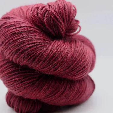 Yarnadelic Sport skein in rich burgundy color, spun from 100% Falklands Corriedale wool, perfect for knitting and crafting projects.