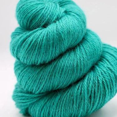 Turquoise skein of yarn on a light gray background