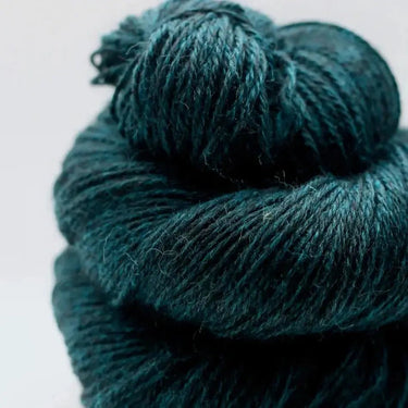 Close-up of Yarnadelic Sport yarn in deep teal, spun from 100% Falklands Corriedale fiber, showcasing its soft texture and rich color.