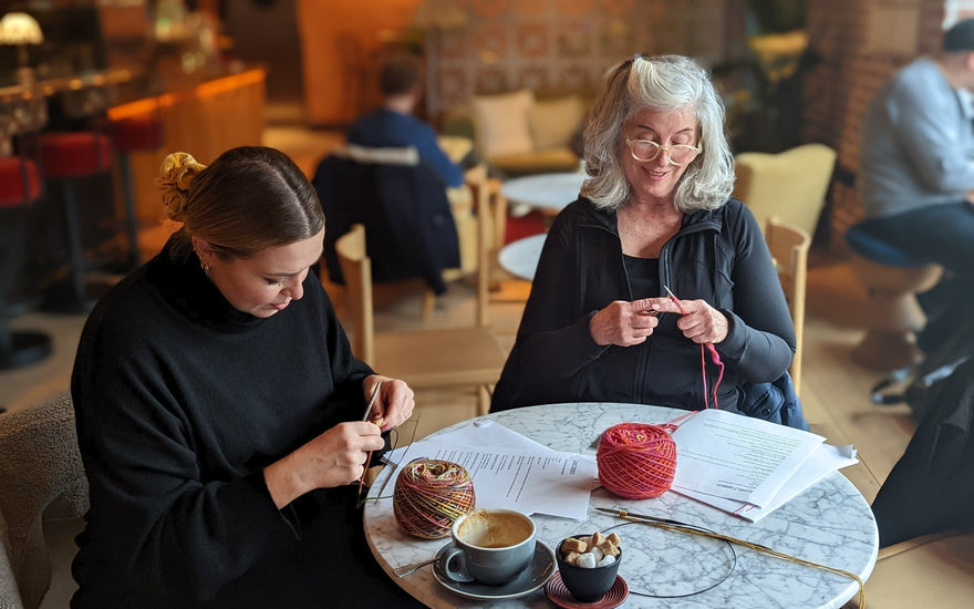 People knitting around a table from yarn shop, Knit With Me in Richmond UK.