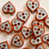 Heart-shaped ceramic tiles with decorative patterns on a light background