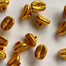Gold-colored coffee bean-shaped beads on a white background