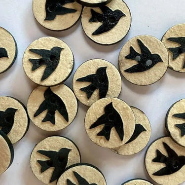 Circular wooden tokens with black bird illustrations on a white background