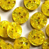 Close-up of yellow buttons with a glittery texture on a white background