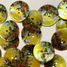 Collection of 15mm glossy shell buttons with flowers (L2) on yellow background, highlighting floral design and shell material.