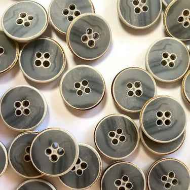 Pattern of gray buttons with gold edges on a white background