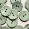 Multiple light green buttons with two holes on a white background