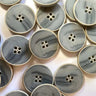 Collection of gray buttons with gold edges on a white background