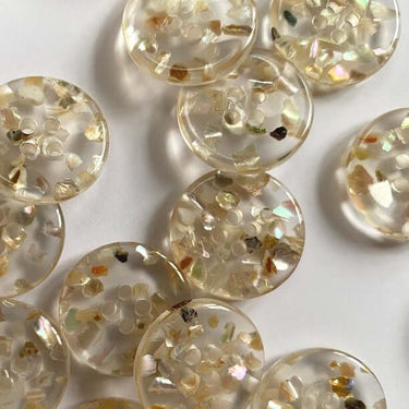 20mm transparent buttons embedded with real shell chips (K7) shown in a cluster highlighting their unique design and craftsmanship.