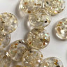 20mm transparent buttons embedded with real shell chips (K7) shown in a cluster highlighting their unique design and craftsmanship.