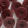 Close-up of maroon buttons with a textured surface on a white background