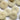 Close-up of multiple white buttons with four holes on a white background
