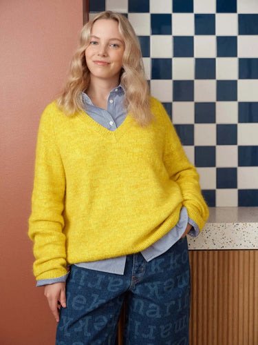 Person wearing a bright yellow sweater featured in 52 Weeks of Sweaters collection.