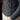 Close-up of a person wearing a blue knitted sweater with intricate patterns.