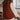 Person wearing a brown knitted vest in a kitchen setting