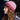 Woman wearing a pink knitted hat and blue sweater against a blurred background