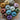 Twelve colorful balls of Marie Wallin British Breeds Aran yarn on patterned fabric.