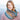 Woman wearing colorful knitted scarf from British Breeds Aran yarn, perfect Knitting Gift for cozy and fashionable winter style.