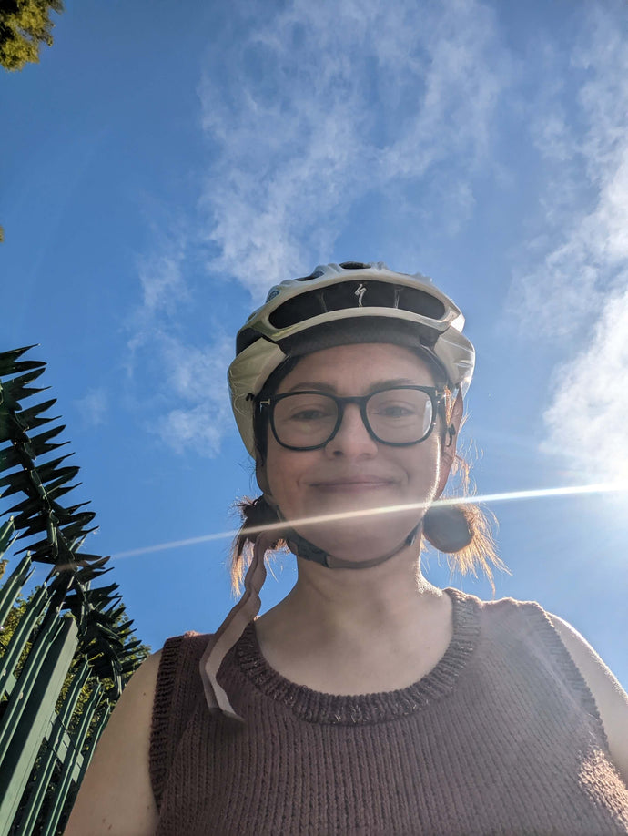 Yarn Shop owner on a bike with helmet to the knitting shop
