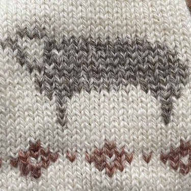 Close-up of a knitted pattern using Duplicate Stitch featuring a sheep design, showcasing embroidery technique for knitwear embellishment.