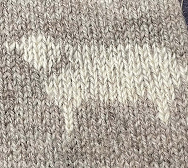 Close-up of knitted fabric showcasing Duplicate Stitch technique in beige and white yarn by Justine Lee workshop.