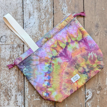 Ice Dyed Project Bags - XLarge shown on wooden floor, multicolored tie-dye effect, Jose Rose brand, with strap and zipper closure.