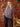 Smiling woman wearing a knitted sweater showcasing "52 Weeks of Sweaters" pre-order book backdrop
