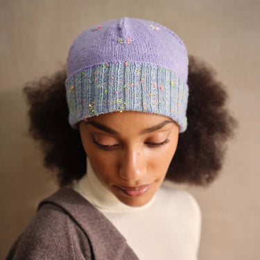 Woman wearing a knitted purple beanie showcasing Beaded Colourwork