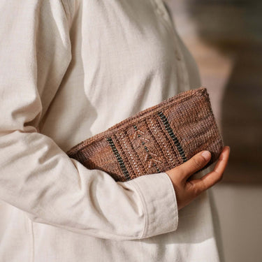 Person holding a knitted beaded clutch, showcasing Beaded Colourwork, from the book 'Beaded Colourwork: A Modern Approach to Knitting'.