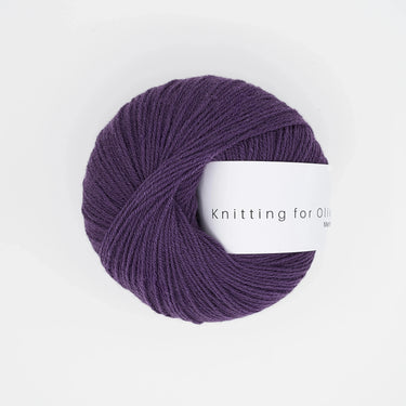Knitting For Olive Merino yarn in deep purple, perfect for cozy knitting projects with natural fiber benefits.