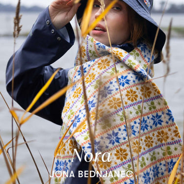 Model wearing a colorful scarf featured in Archipelago Knitting pre-order collection