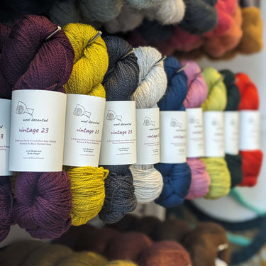 Colorful skeins of Wool Decanted Vintage 23 4ply Yarn in various shades on display.