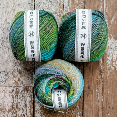 Ito worsted weight yarn in vibrant multicolor skeins on a wooden surface