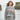 Model wearing a sweater from Aran by Marie Wallin with Fairisle motifs, standing by the sea.