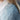 Close-up of a light blue knitted cardigan with a white shirt underneath.